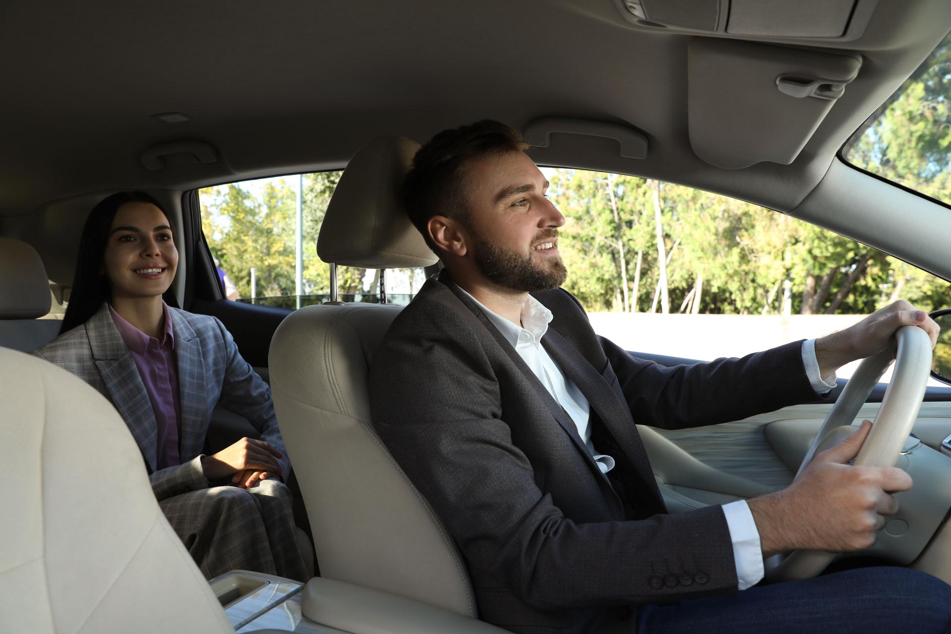 Young woman and driver in modern car